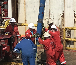 Roughneck team moving a drill pipe